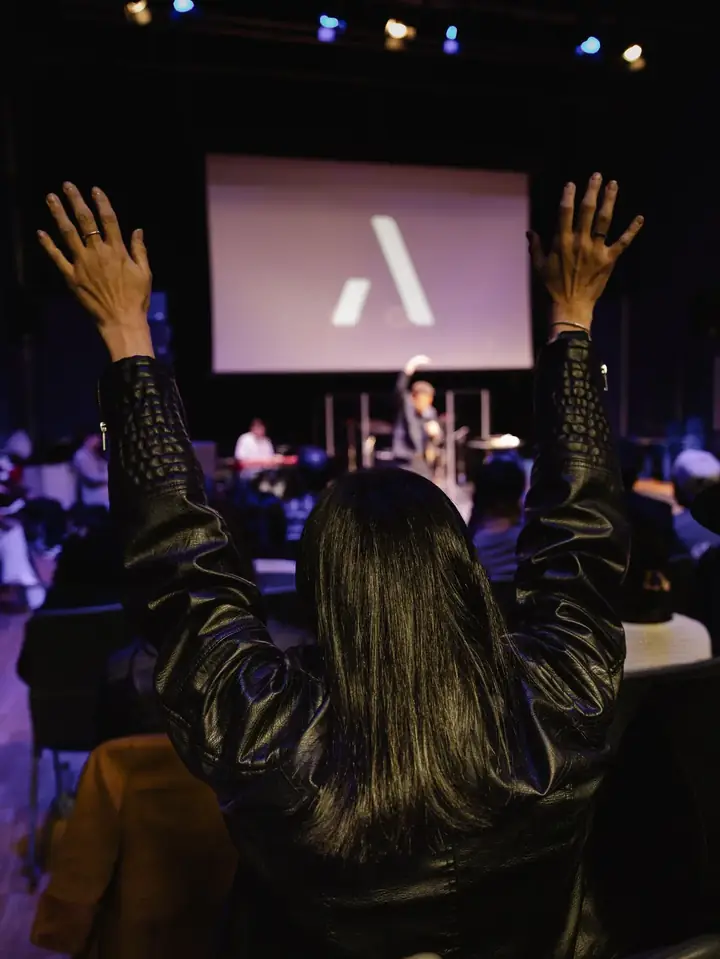A worship gathering with raised hands in a church
