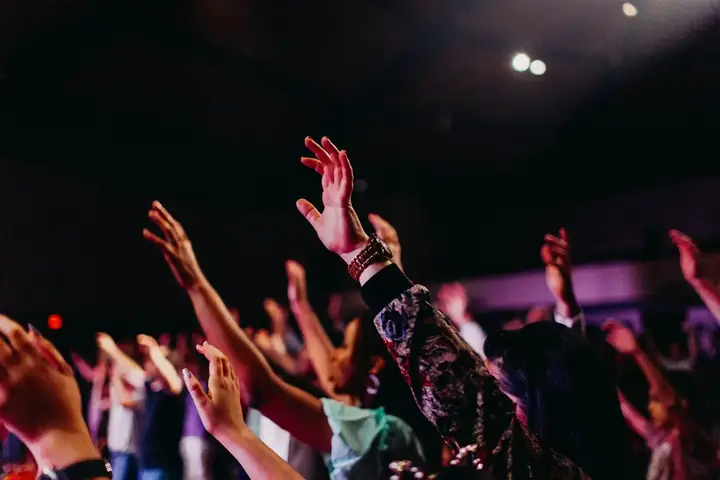 A church congregation with raised hands in worship